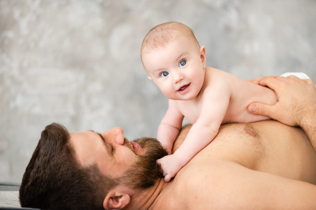 Portrait of cute baby girl lay on father