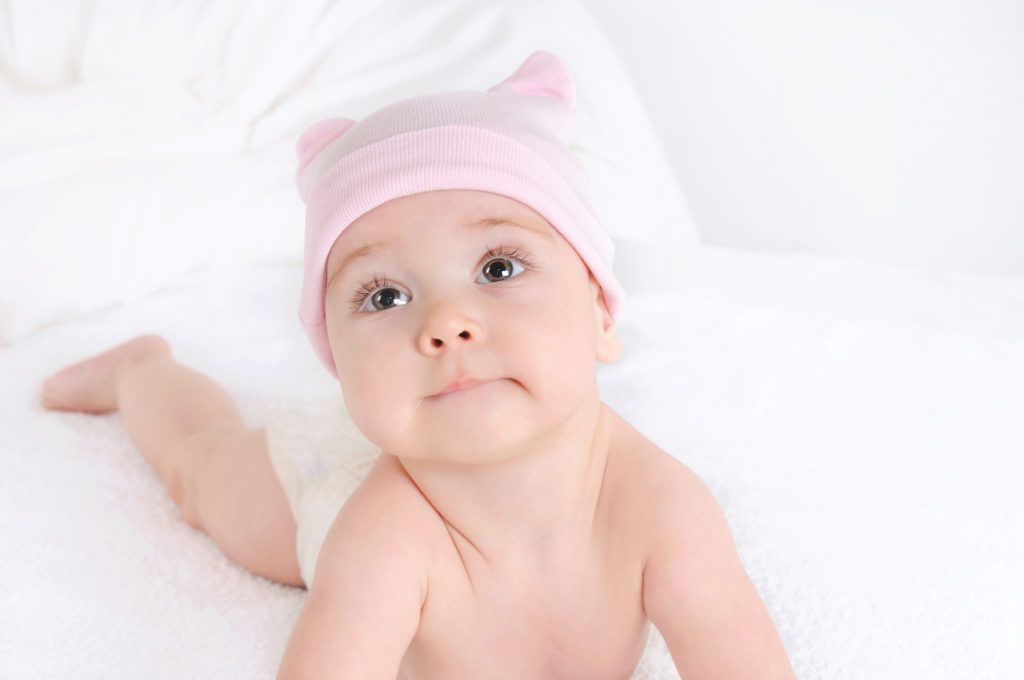 Close up picture of a cute little baby girl wearing at pink hat